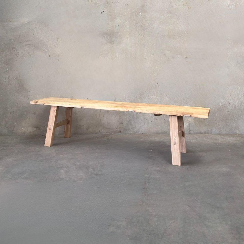 Wooden bench against a concrete wall